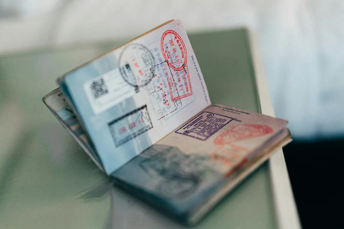Open passport pages covered in immigration stamps
